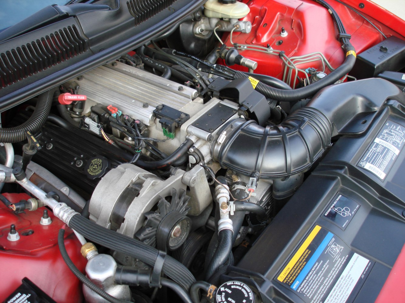 Engine bay with visible intake, alternator, and fluid components