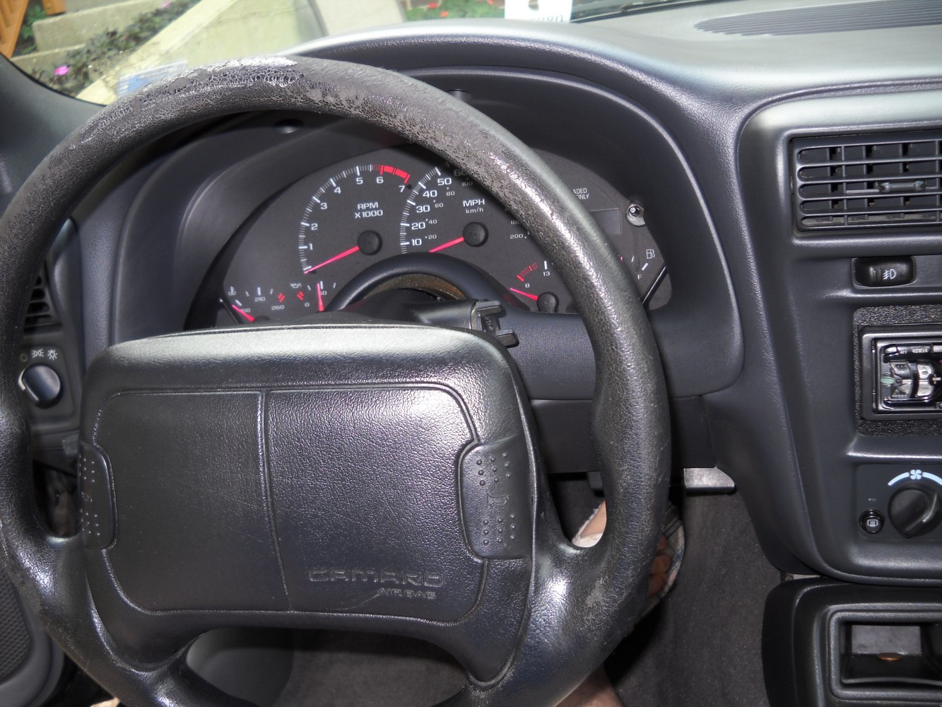 Steering wheel and instrument cluster with speedometer and RPM gauges
