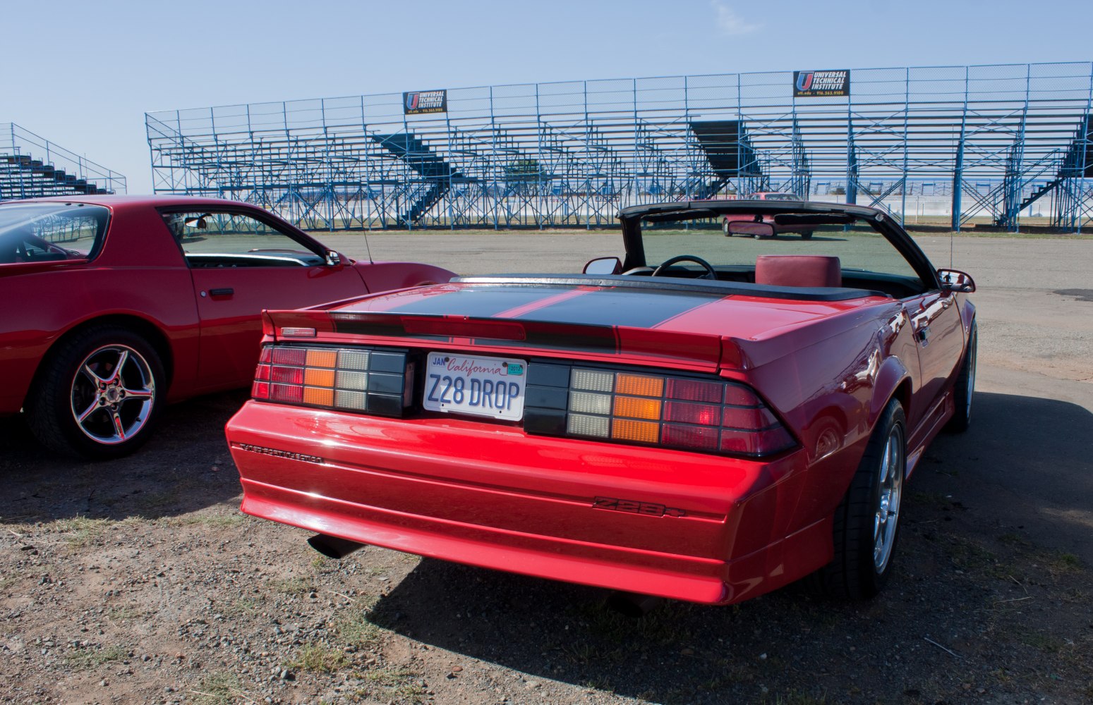 Rear view of a red convertible with distinct tail lights and rear spoiler.