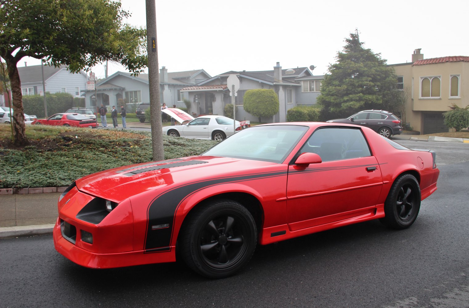 Red coupe with black stripes and black wheels