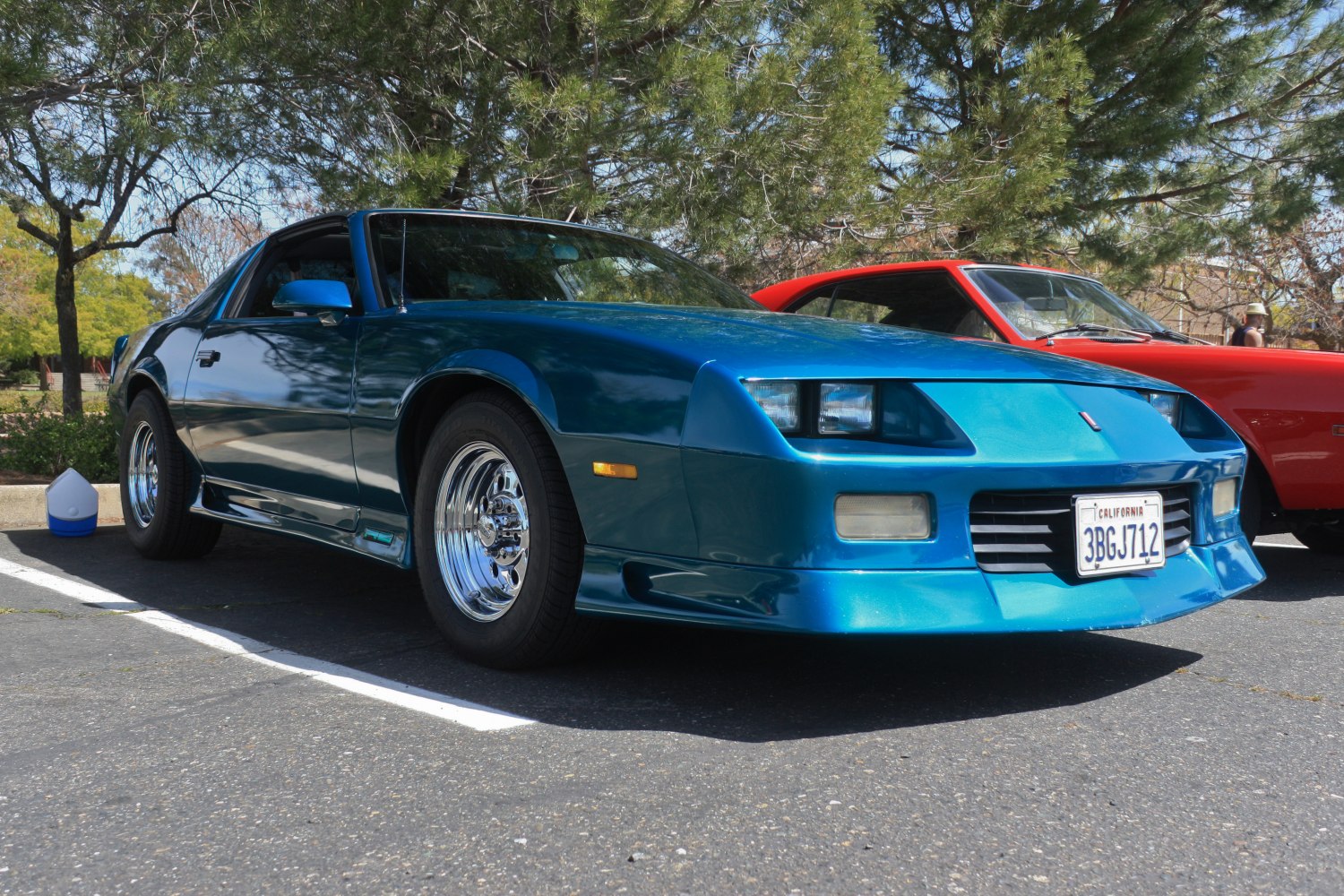 Blue car front view with pop-up headlights and chrome wheels