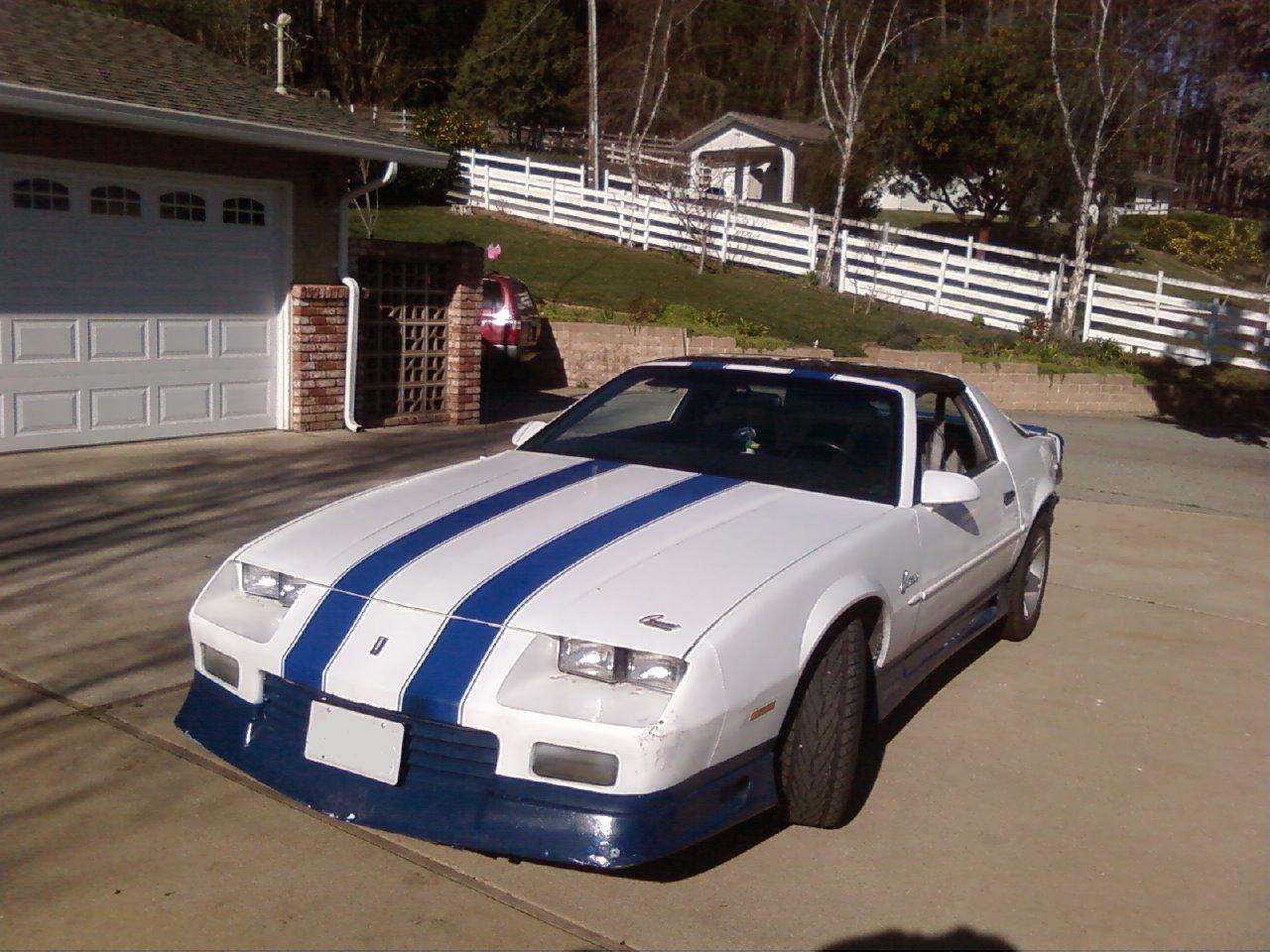 White sports car with blue racing stripes and sleek front end