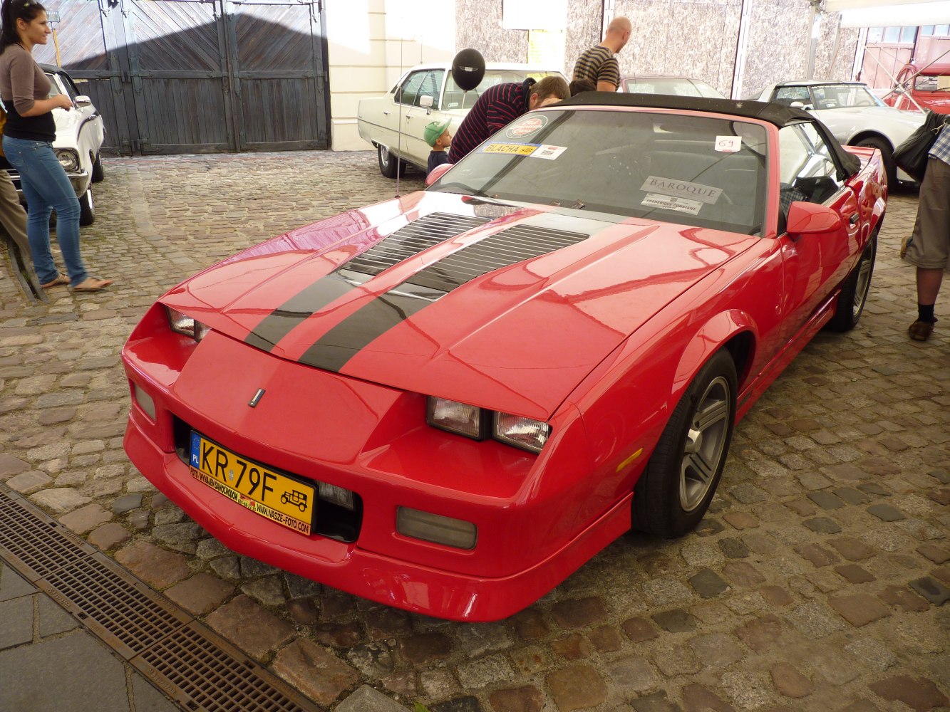 Red convertible with black hood stripe and pop-up headlights