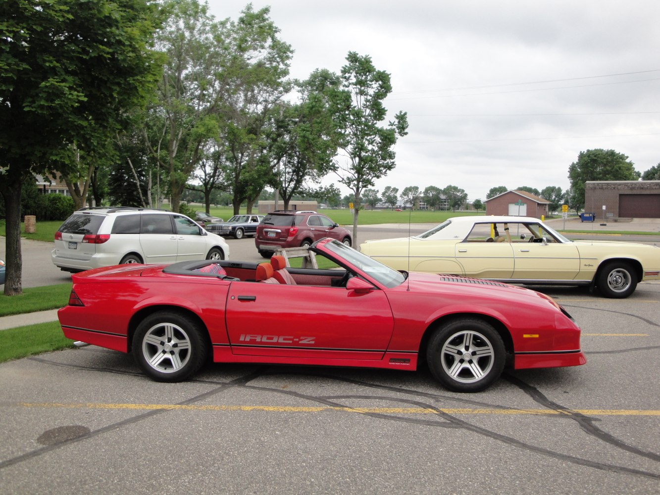 Red convertible sports car side profile with IROC-Z decal.