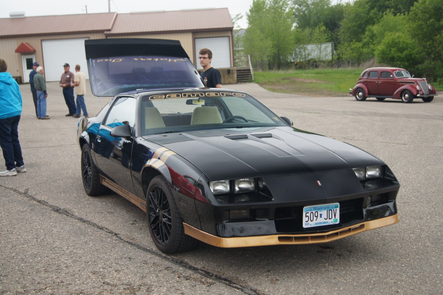 Black sports coupe with gold accents and pop-up headlights