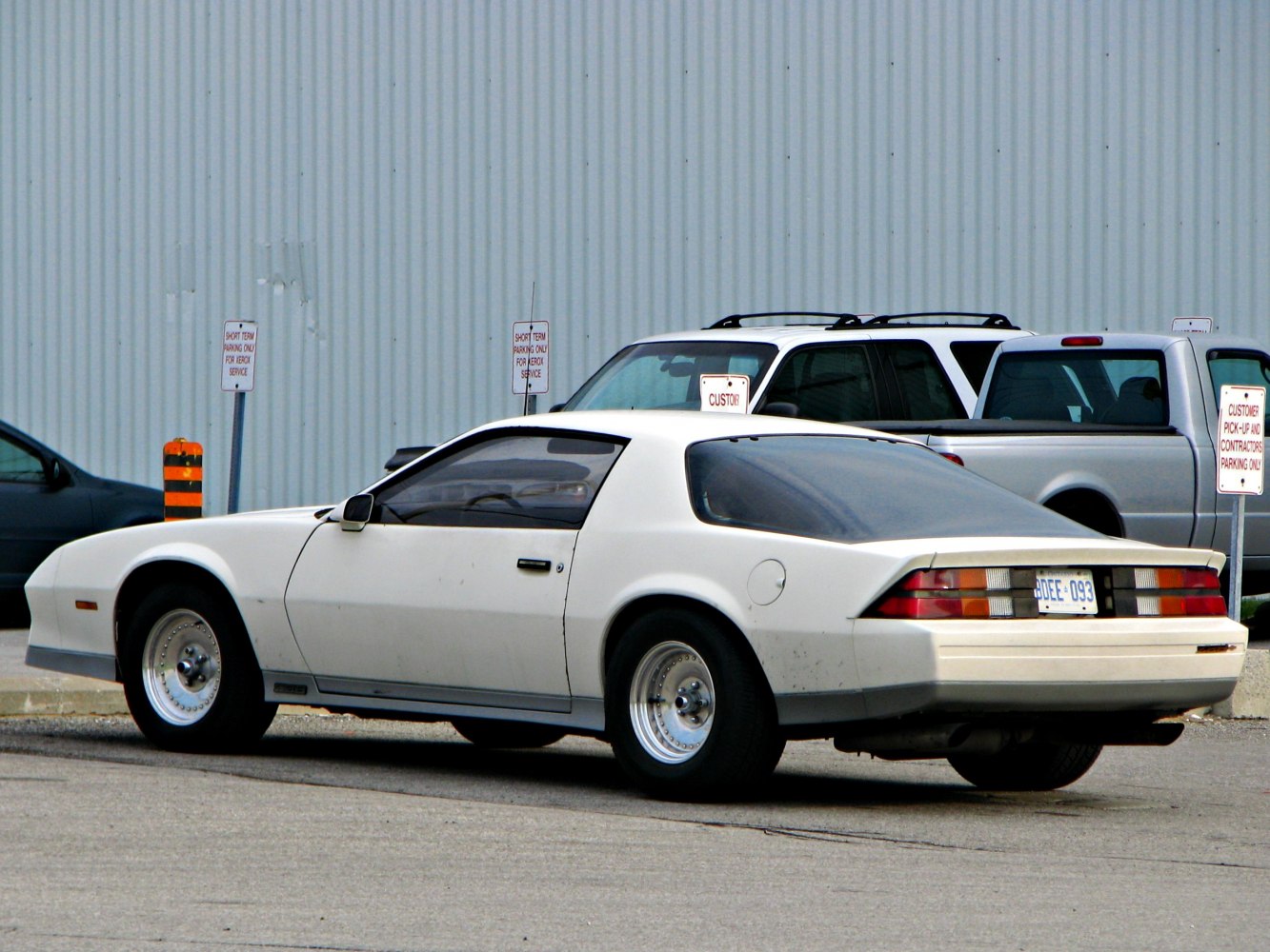 1980s sports coupe side view with rear spoiler and classic wheels