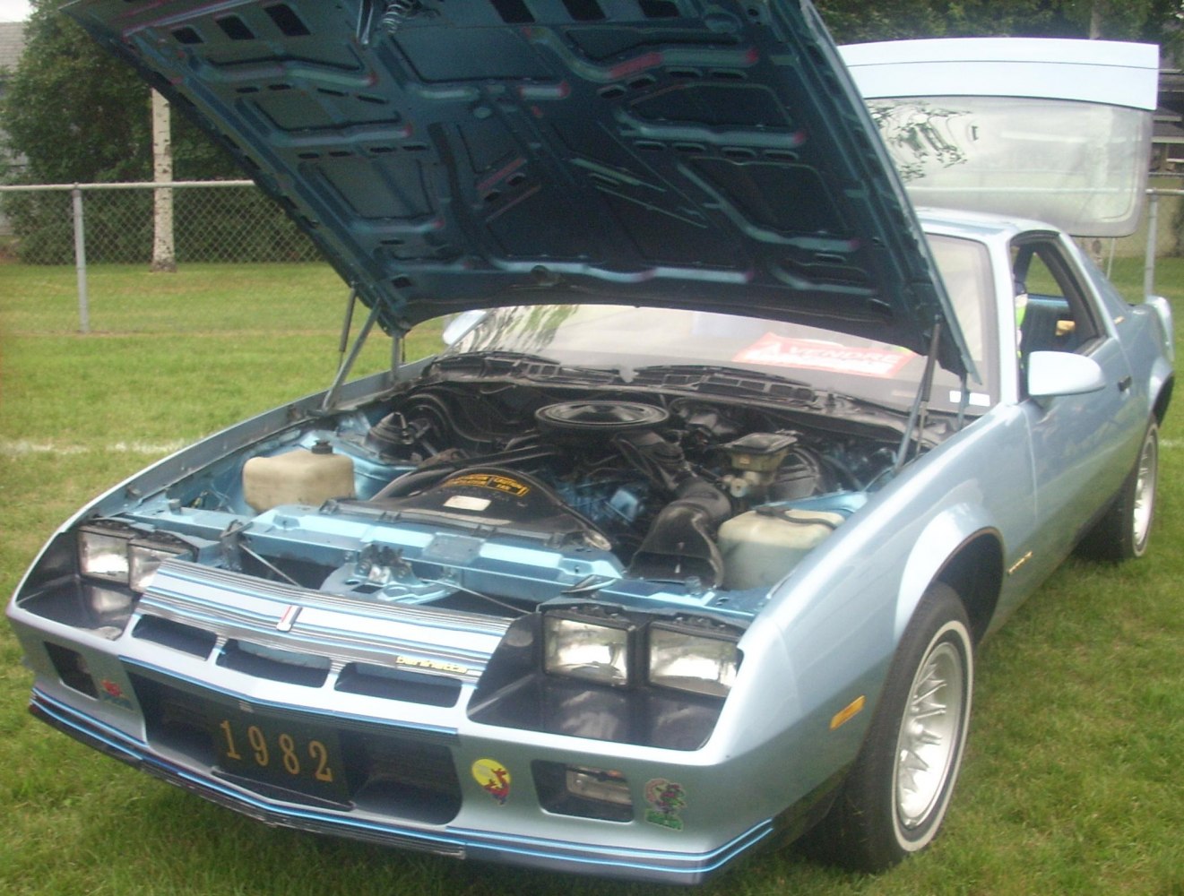 Front view of a car with open hood revealing engine bay