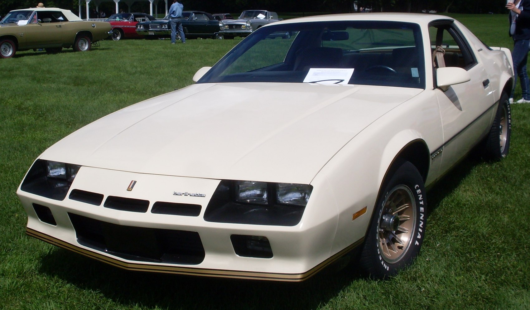 Front angled view with four rectangular headlights and gold rims