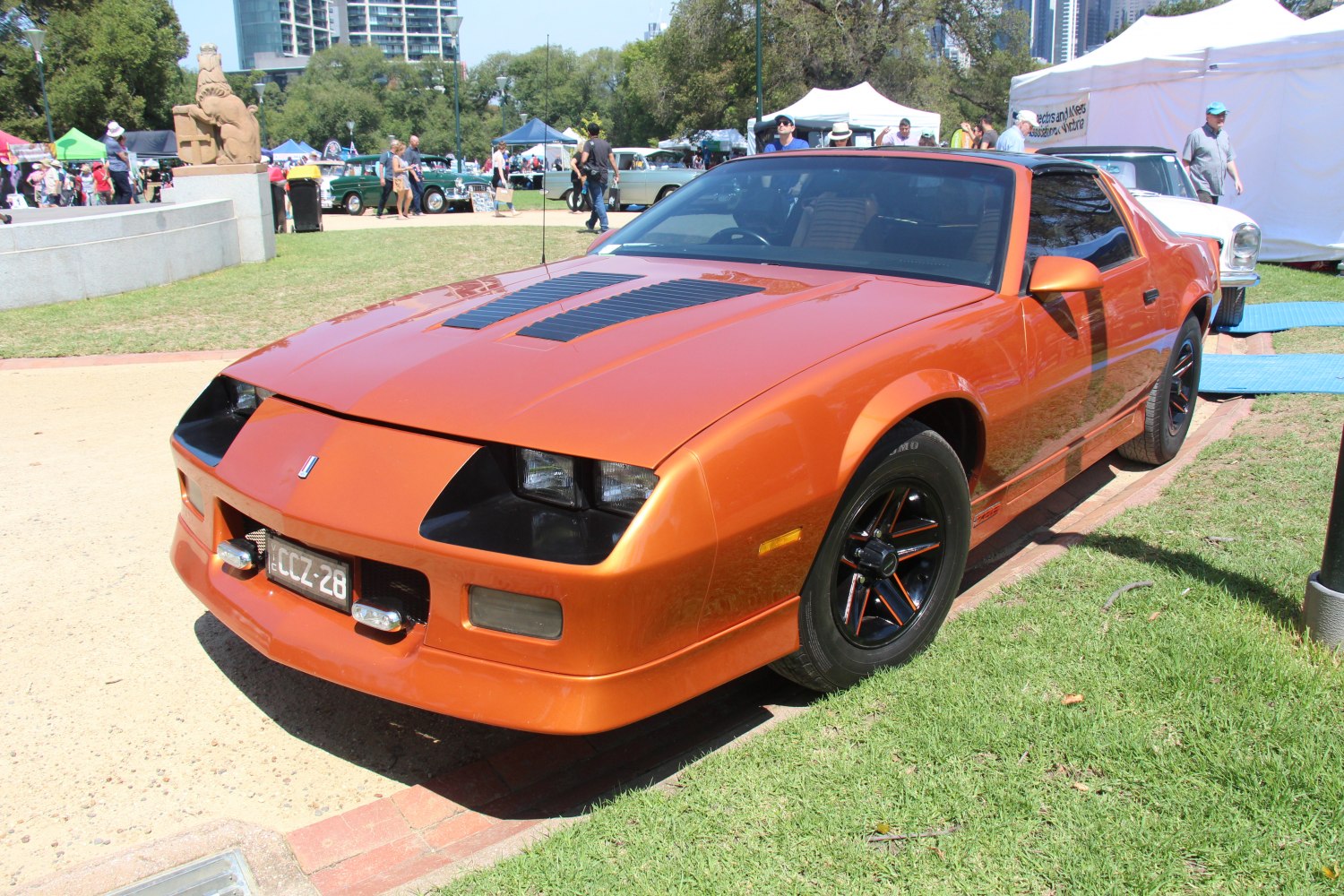 Orange muscle car with black hood vents and retro wheels