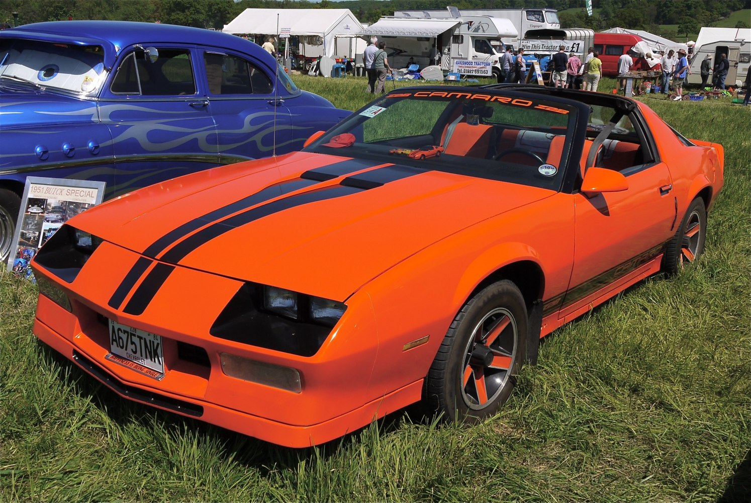 Orange muscle car with black racing stripes and T-top roof