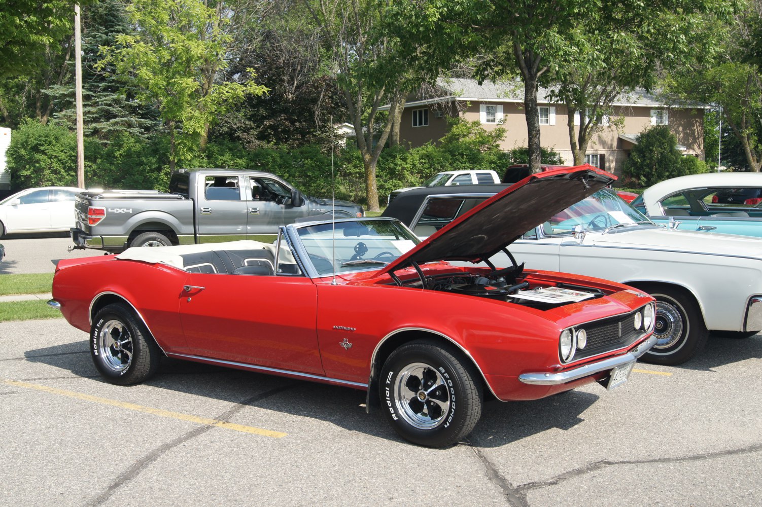 Red vintage convertible with hood open and classic muscle car design