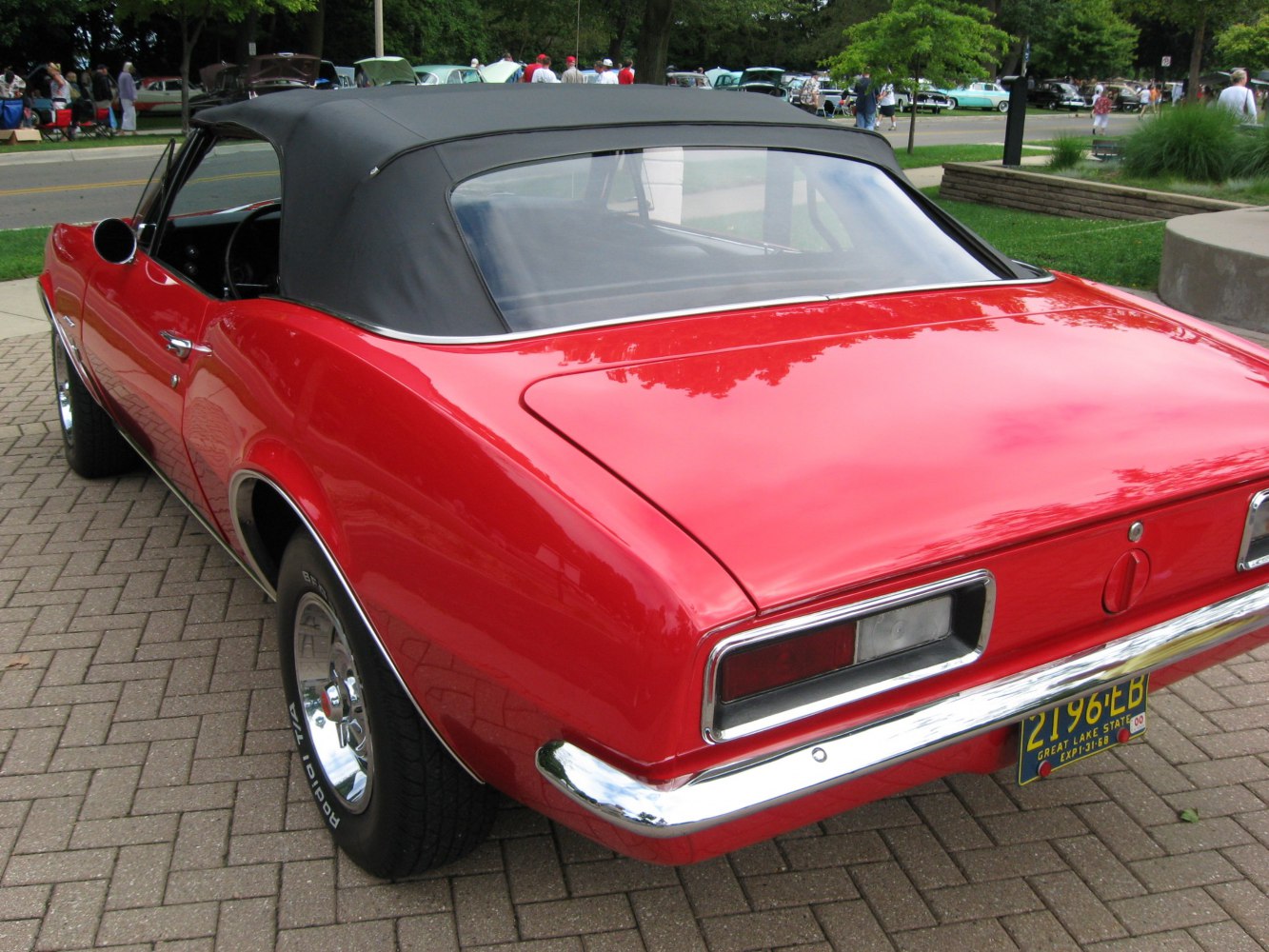 Rear view of a red convertible with black soft top and classic taillights