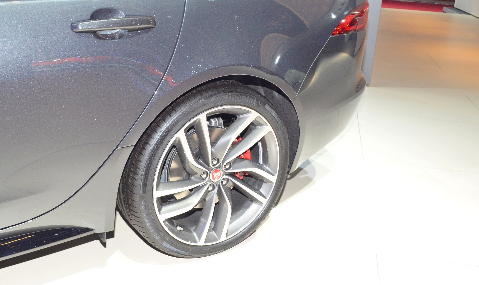 Close-up of rear alloy wheel and Continental tire with red brake caliper