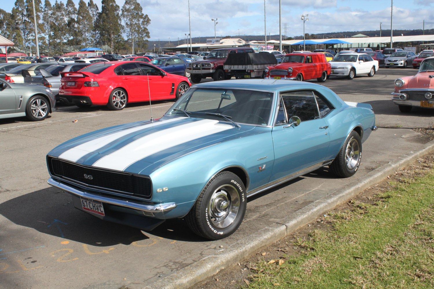 Vintage muscle car with white dual racing stripes and chrome trim