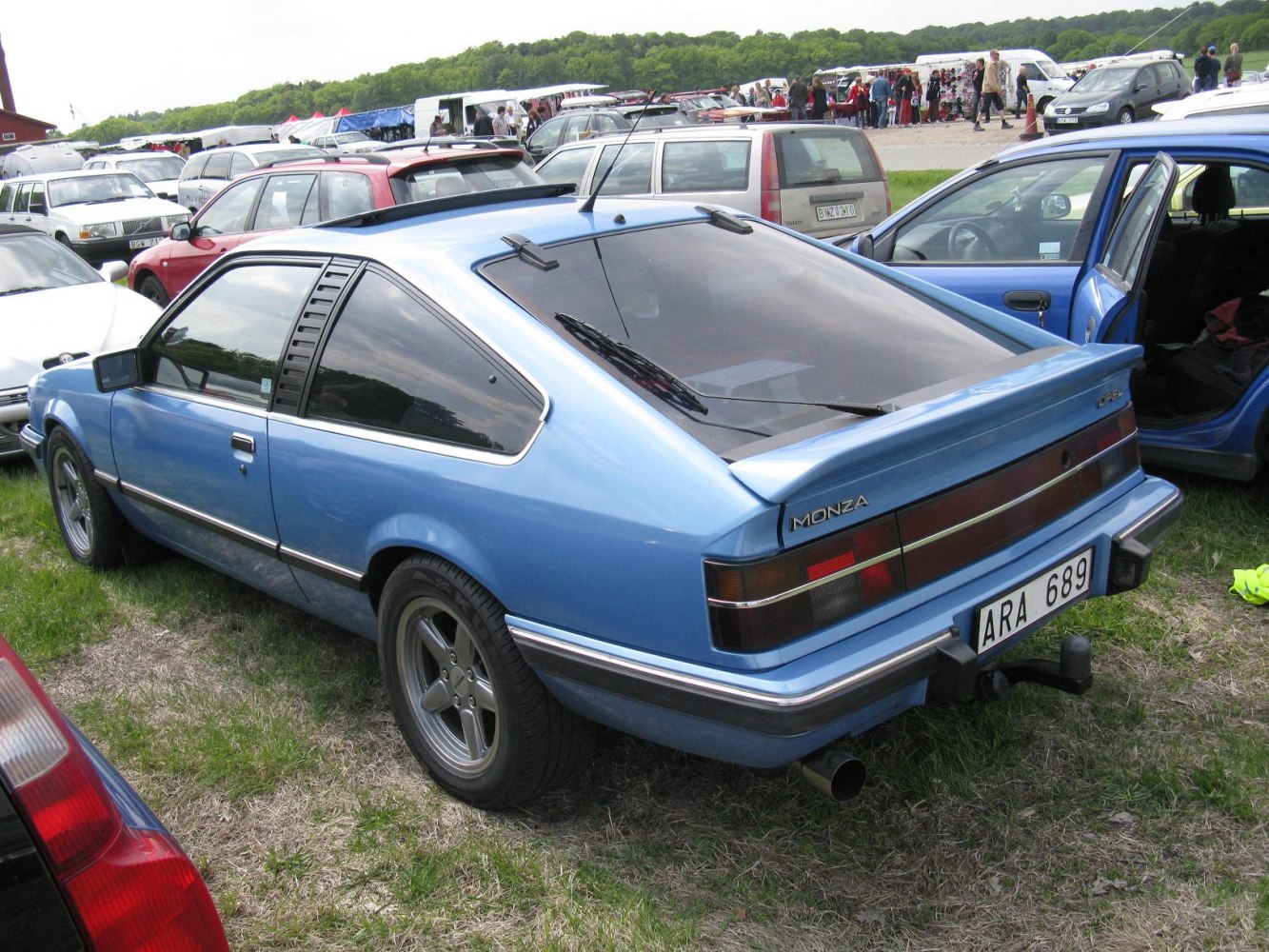 Blue hatchback with rear spoiler and side window louvers