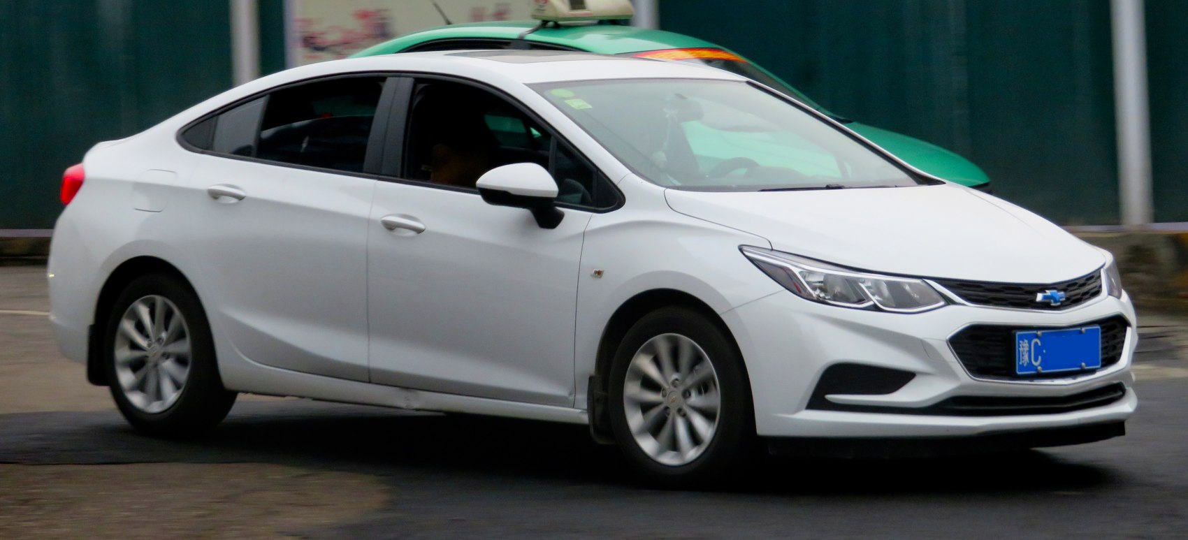 Front side view of a white compact sedan with alloy wheels and sleek design