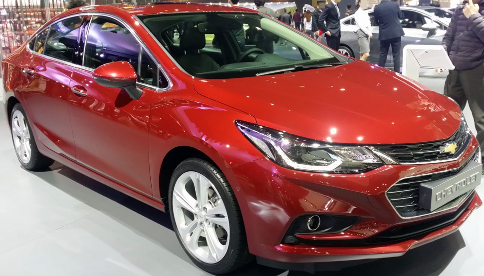 Front side view of red sleek sedan with sharp headlights and aerodynamic design
