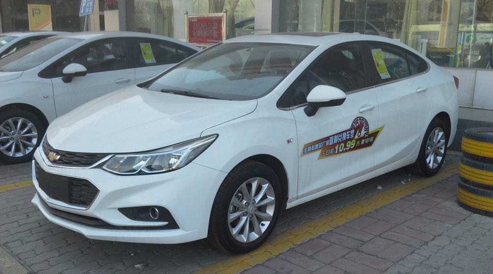 White mid-size sedan front side view with alloy wheels and sleek headlights