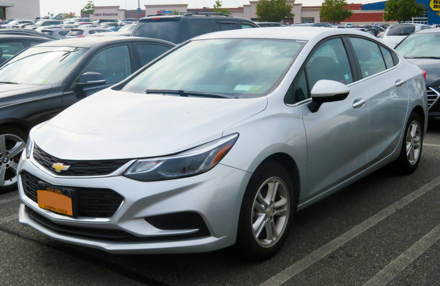 Silver sedan front side with modern headlights and alloy wheels