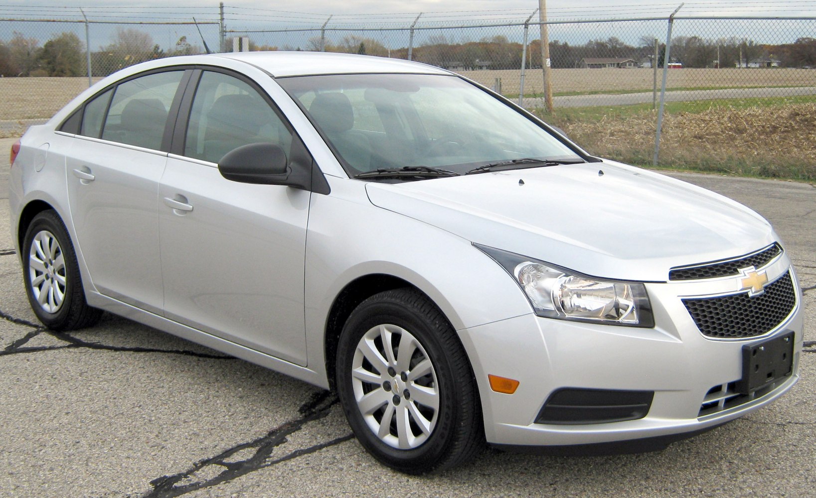 Front-side view of a silver compact sedan with sleek headlights.