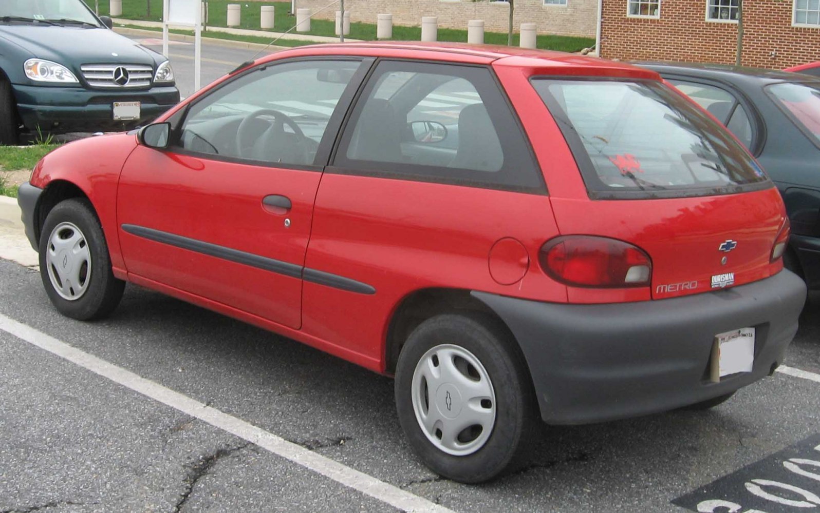 Red hatchback with black bumpers and steel wheels