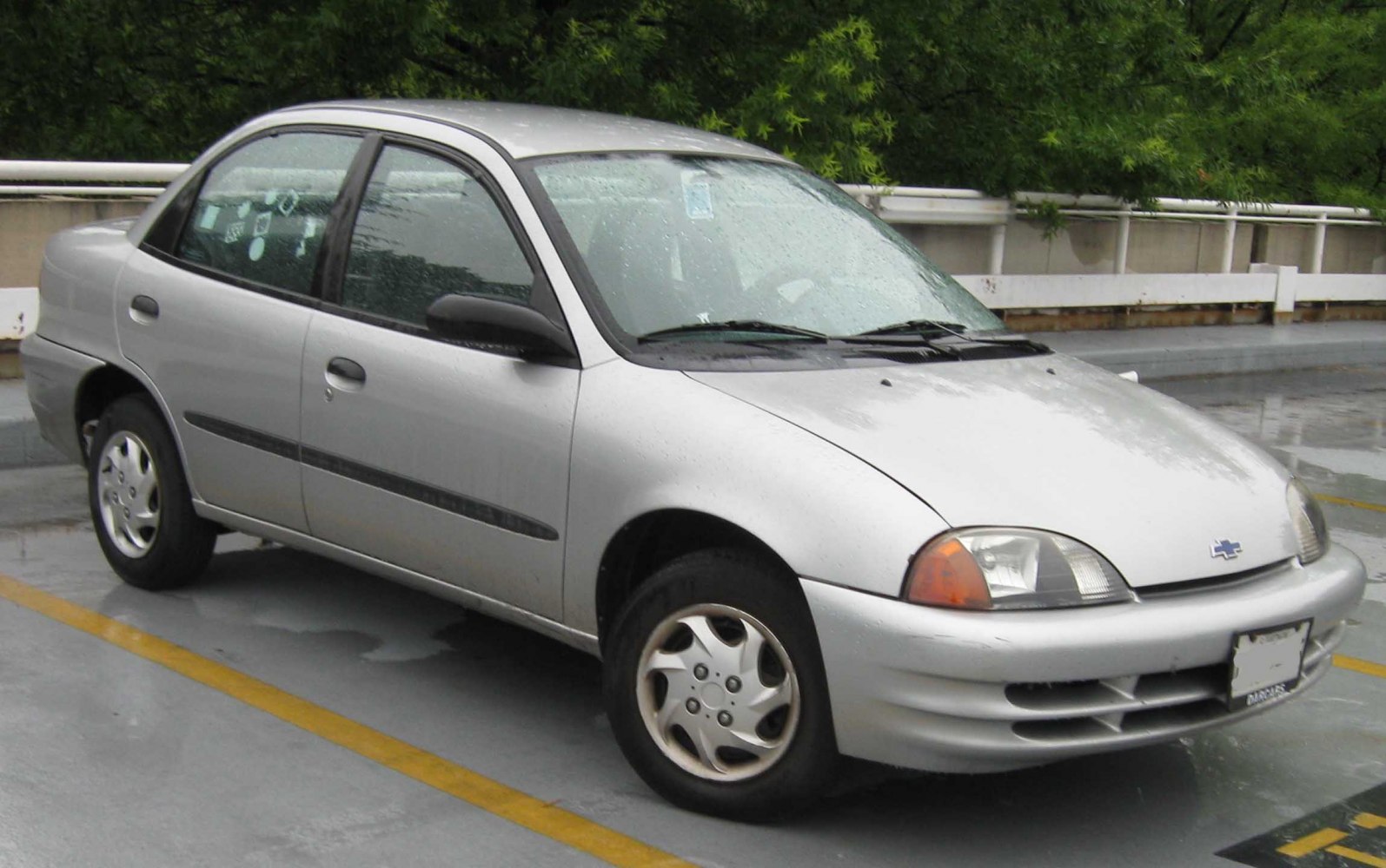 Silver compact sedan with rounded front and side profile in rainy condition