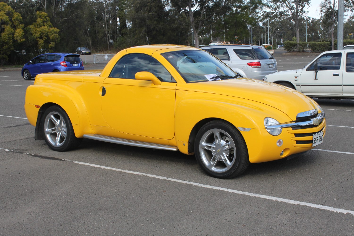 Yellow pickup truck with retro styling and chrome wheels.
