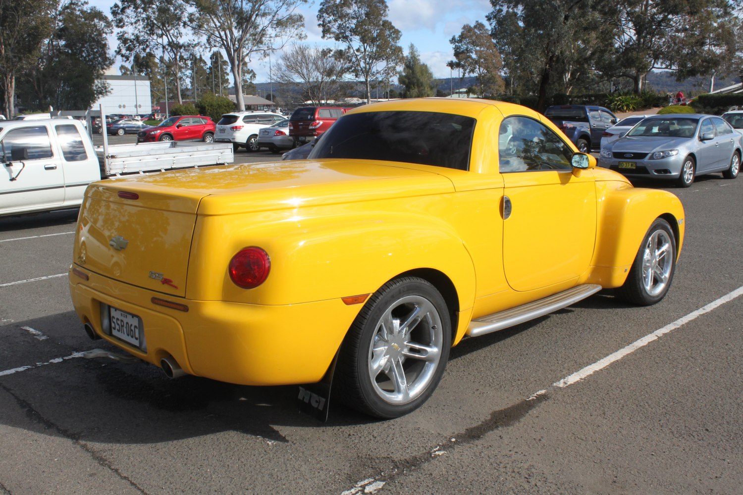 Yellow pickup truck rear view with SS badge and custom wheels