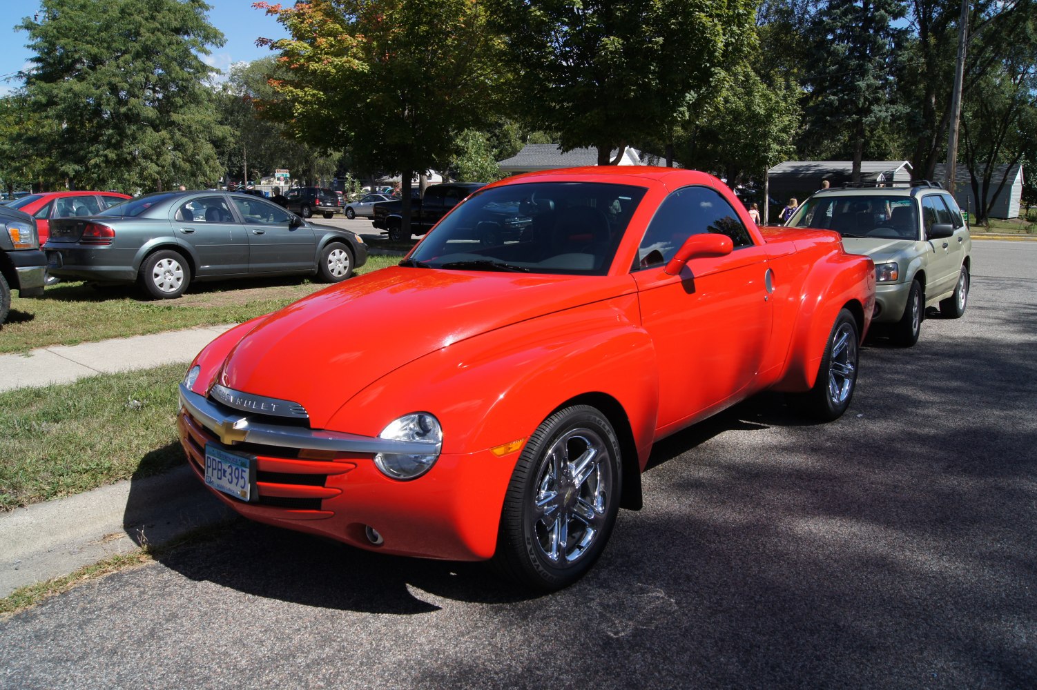 Red retro-style pickup truck with rounded front and chrome wheels.