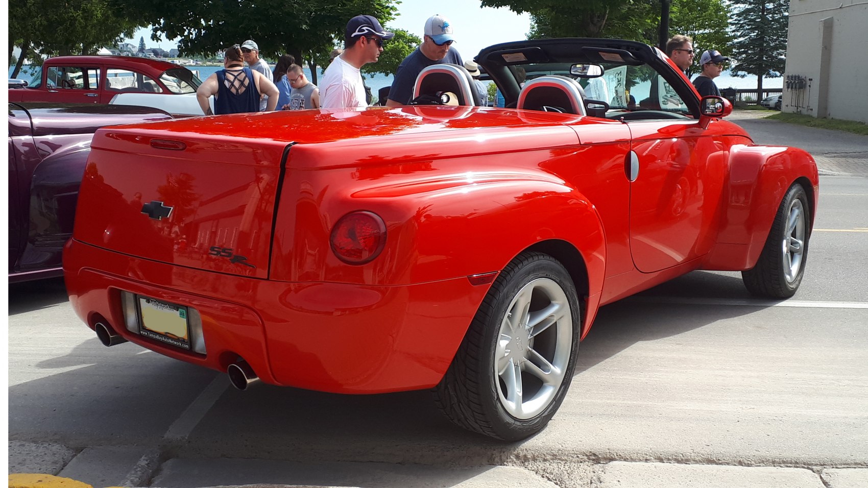 Rear view of red convertible pickup with rounded tail and dual exhausts