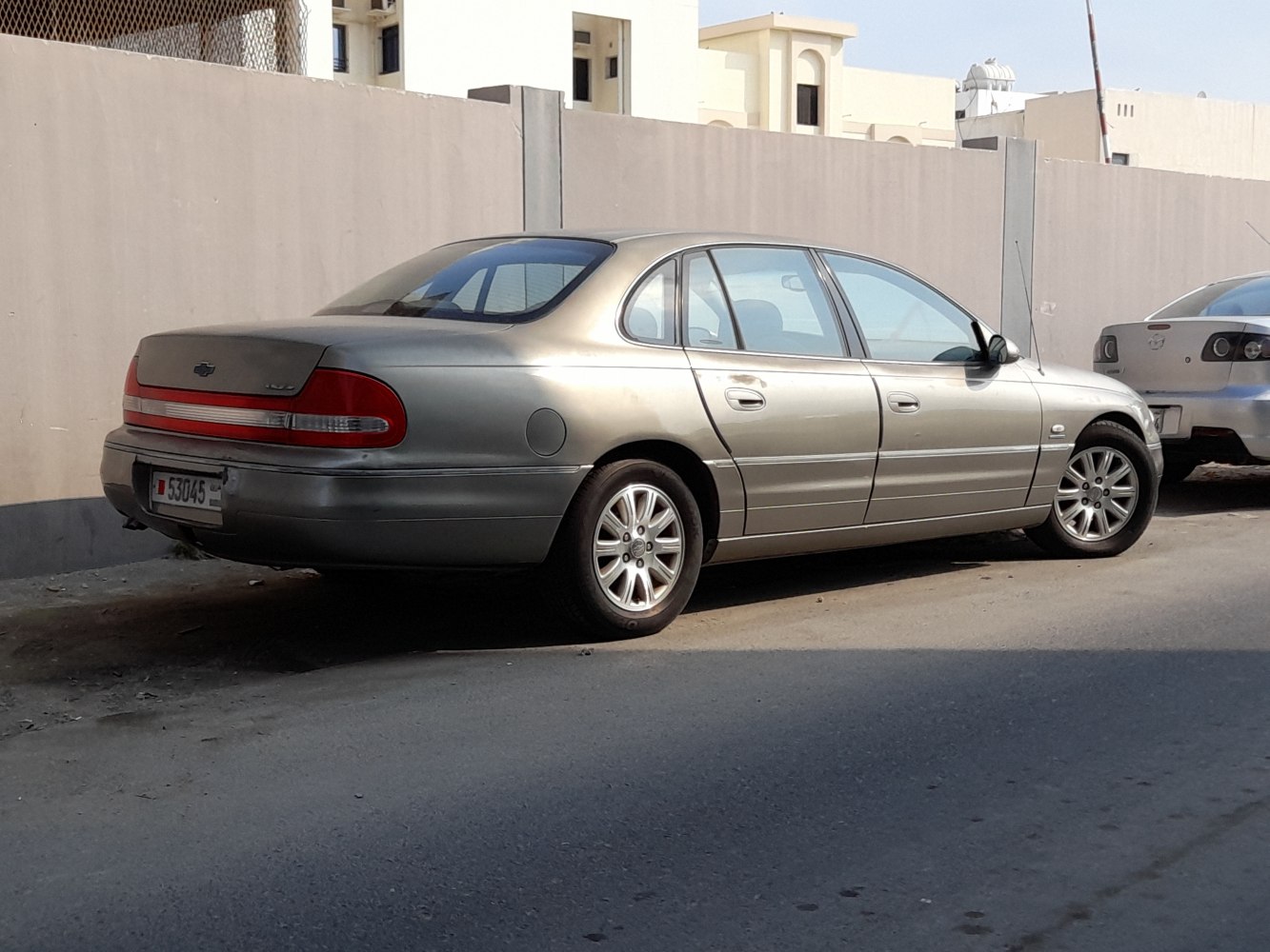 Silver four-door sedan showing rear and side profile with alloy wheels