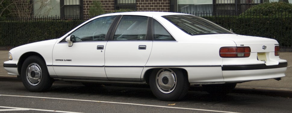 Side profile of a classic full-size four-door sedan with hubcap wheels