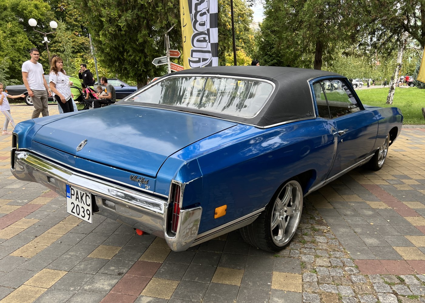 Vintage blue classic car with vinyl roof and chrome details.