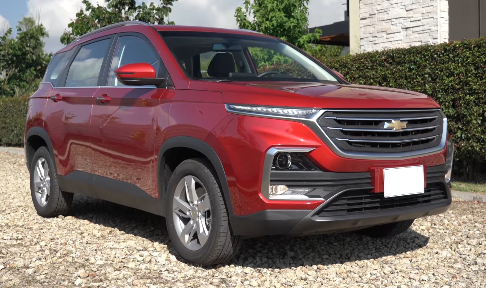 Front side view of red SUV with LED headlights, bold grille, rugged styling
