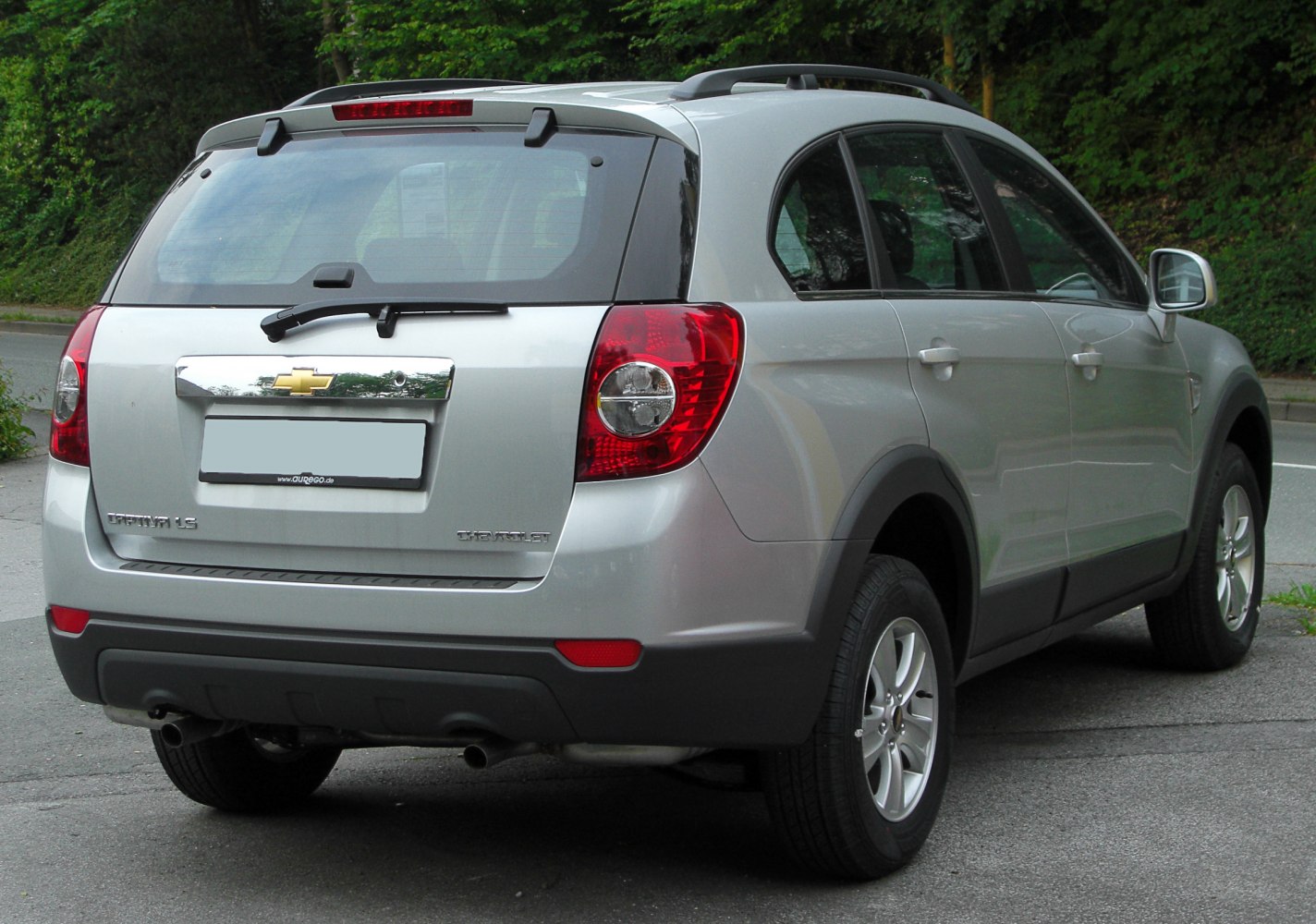 Silver SUV rear view with taillights, rear wiper, and roof rails