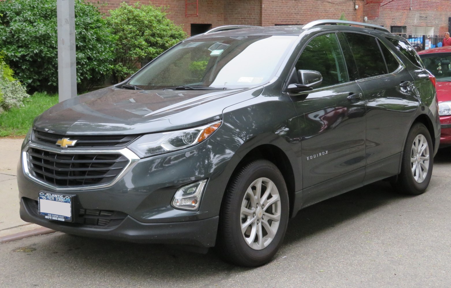 Front-side view of a dark gray SUV with distinct grille and alloy wheels