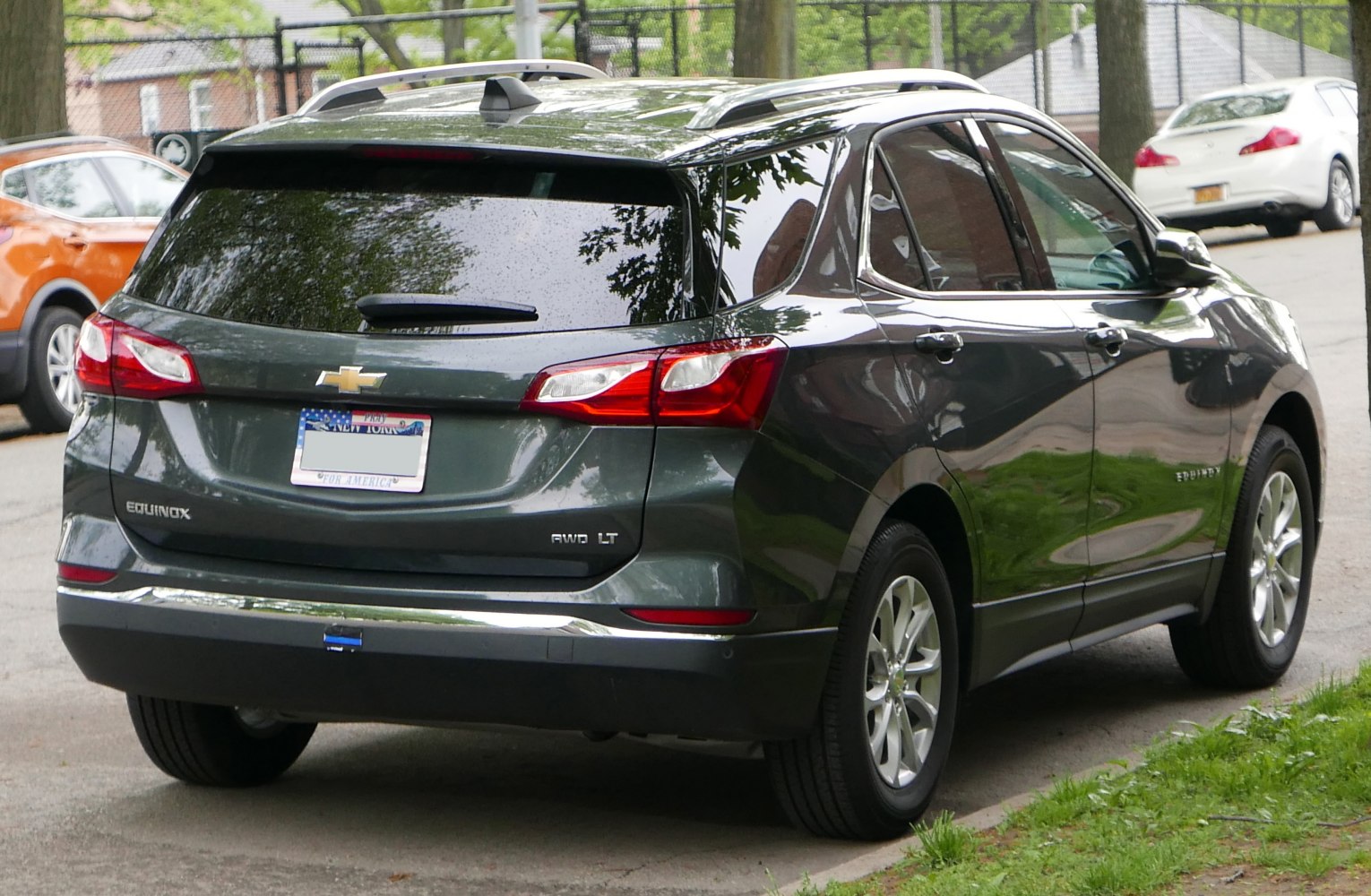 SUV rear view with taillights, tinted windows, and roof rails