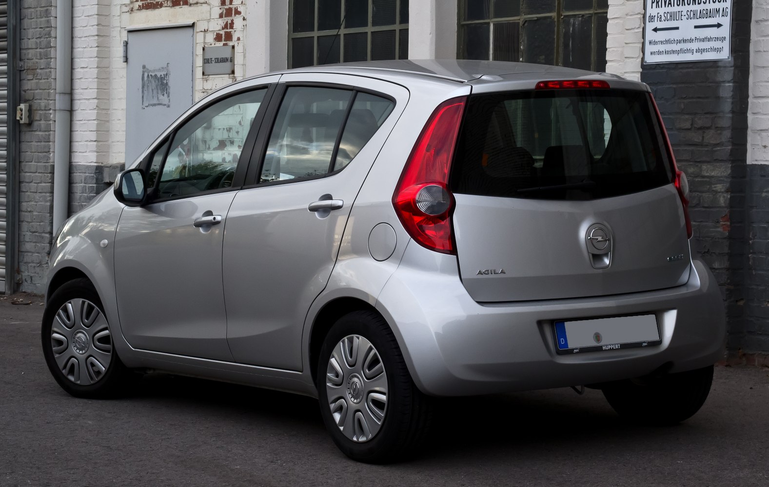 Compact hatchback rear with vertical tail lights and hubcap wheels