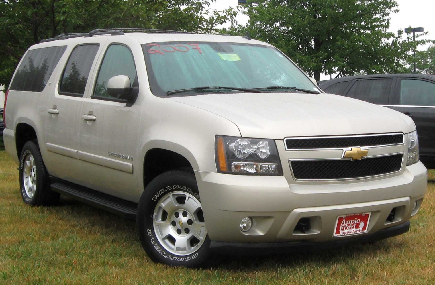 Front side view of large SUV with distinctive grille and headlights