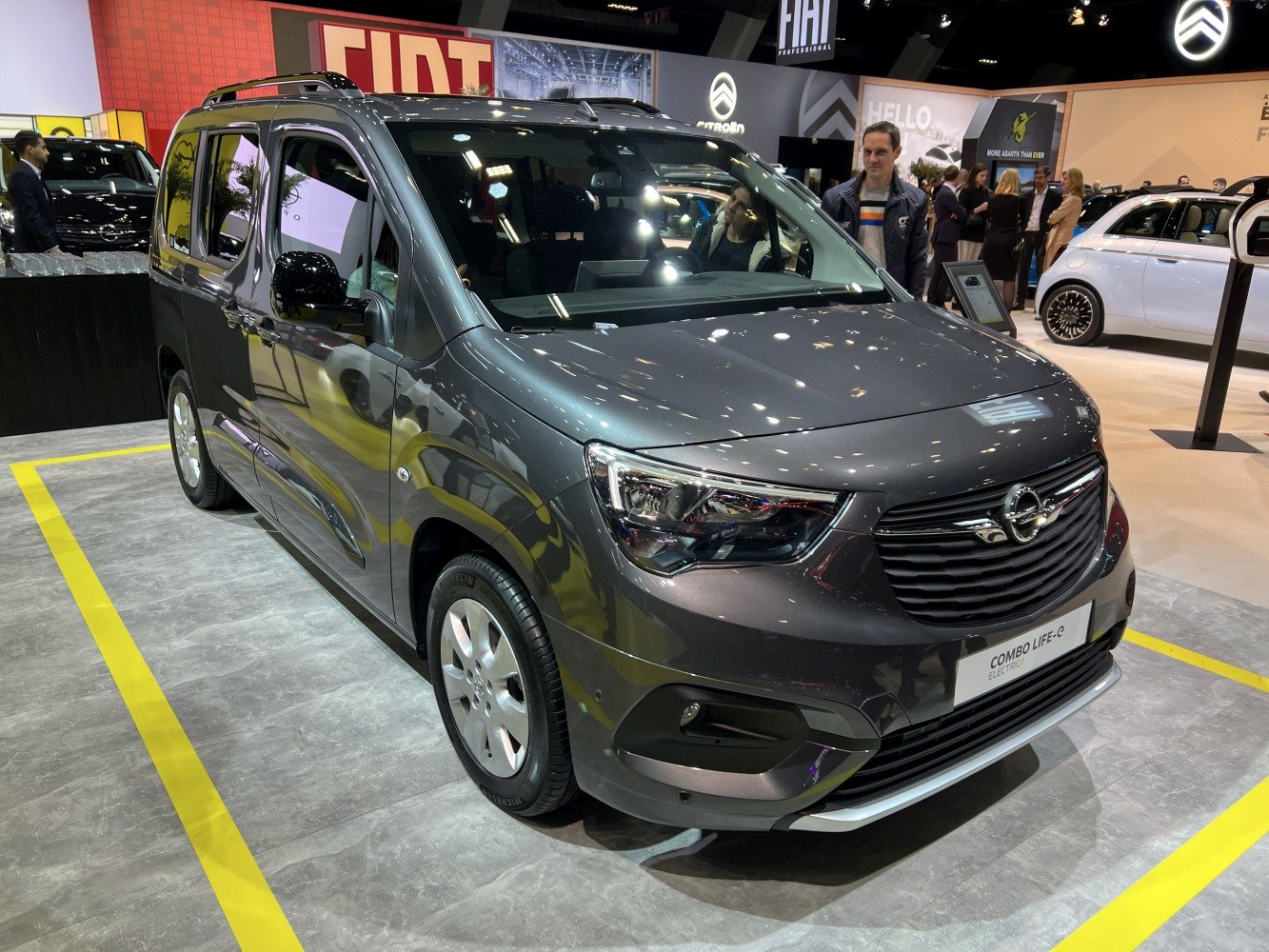 Front and side view of an electric MPV with modern headlights and aerodynamic design.