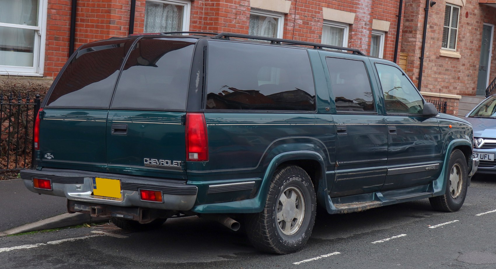 Rear side view of 1990s SUV with tinted windows and large rear profile