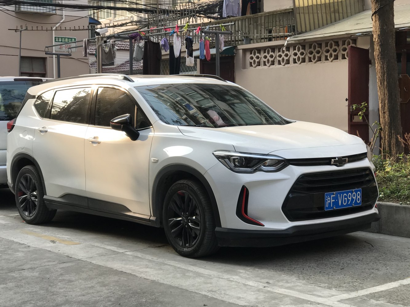 White SUV with black rims and roof rails parked outdoors