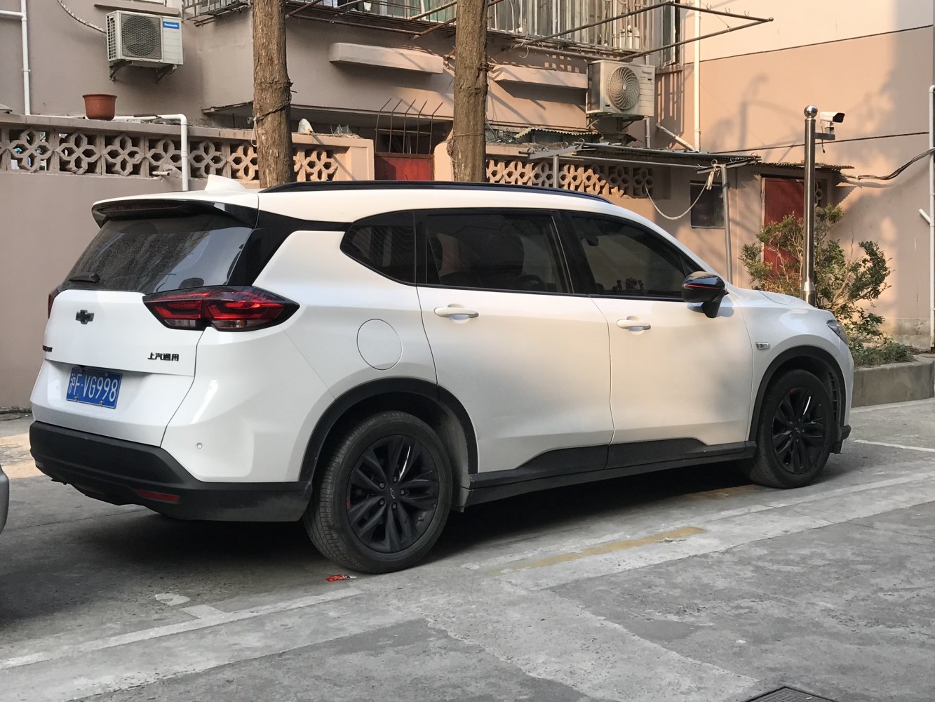 Side rear view of white SUV with black alloy wheels