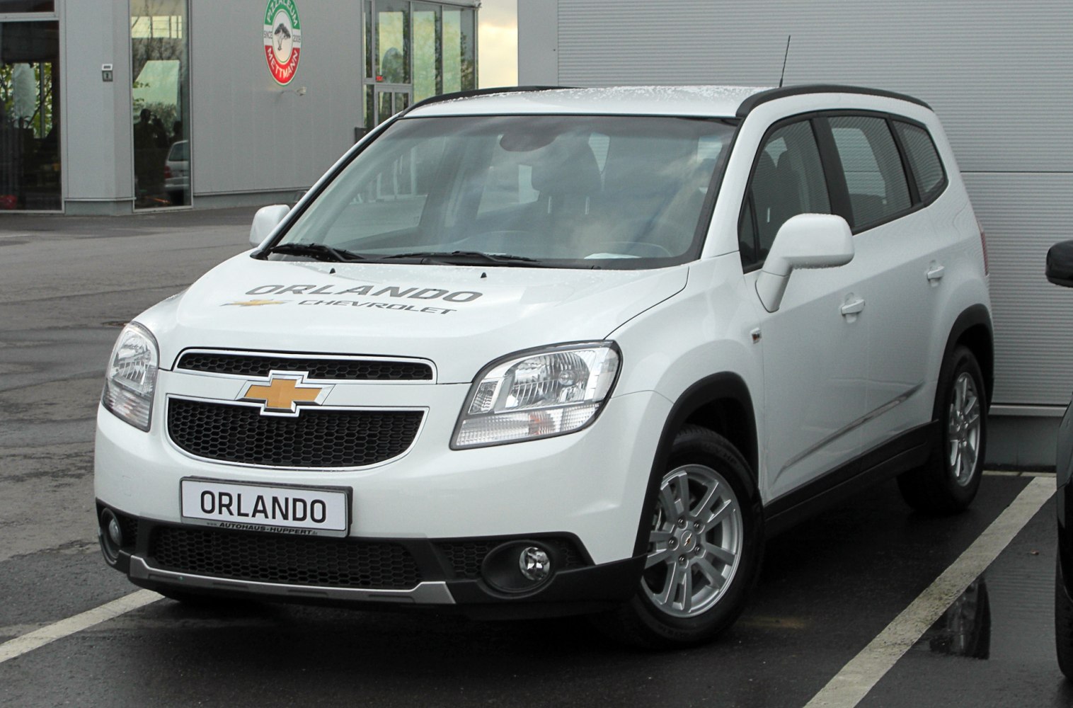 Front view of white compact MPV with grille and alloy wheels