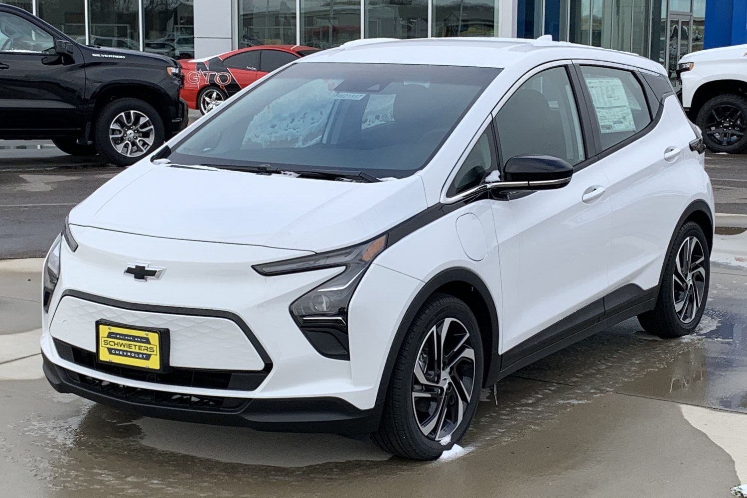 Front 3-4 view of a white electric hatchback with distinct headlight design and alloy wheels