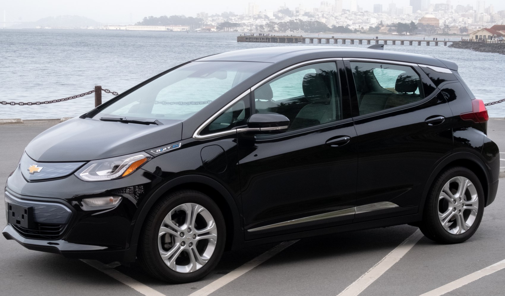 Side profile view of black electric hatchback by waterfront