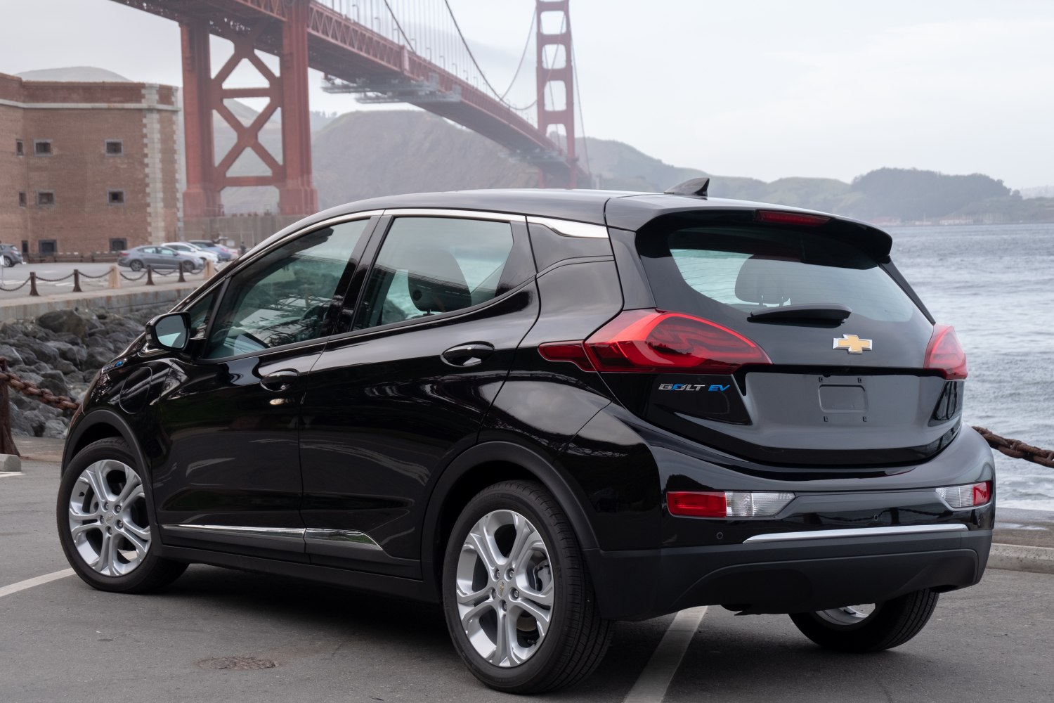 Compact hatchback rear side view with modern taillights and black glossy finish.