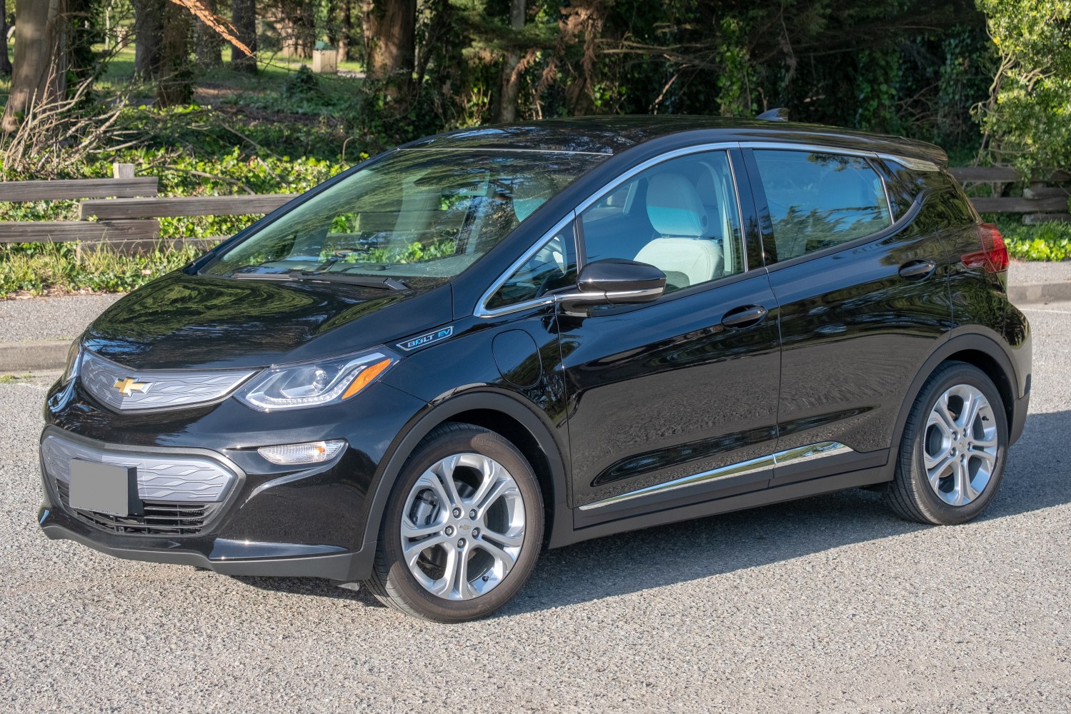 Front side view of an electric hatchback with visible charging port