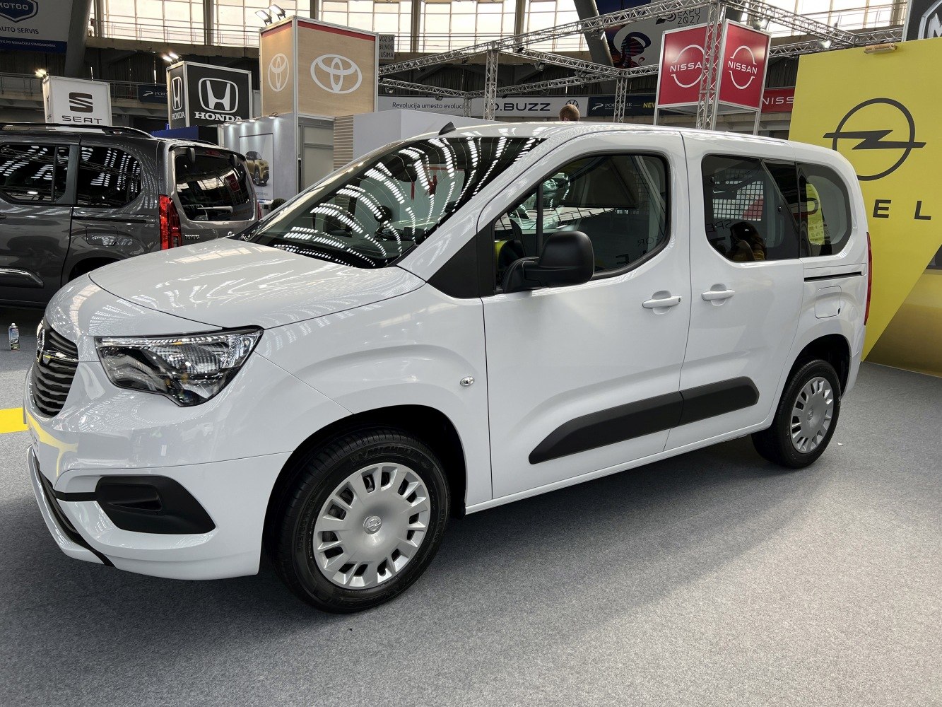 White compact multi-purpose vehicle showing front and side profile