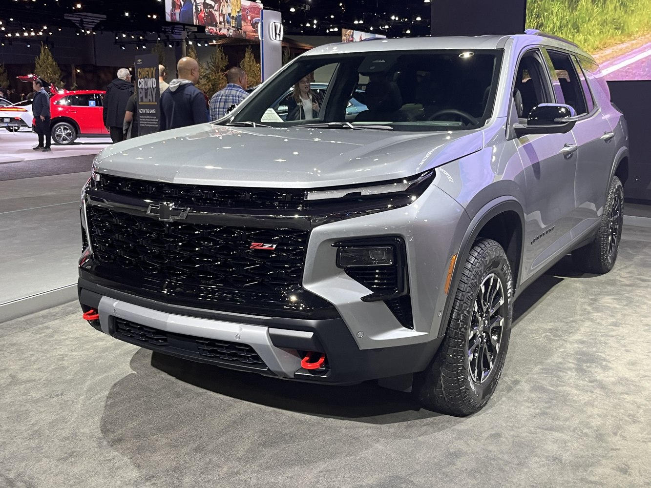 SUV front with black mesh grille and red tow hooks